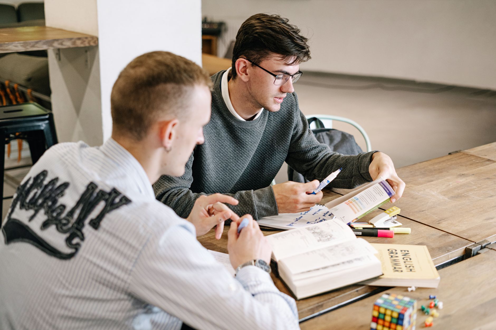 A student preparing for an English proficiency test at a desk with notes and study materials