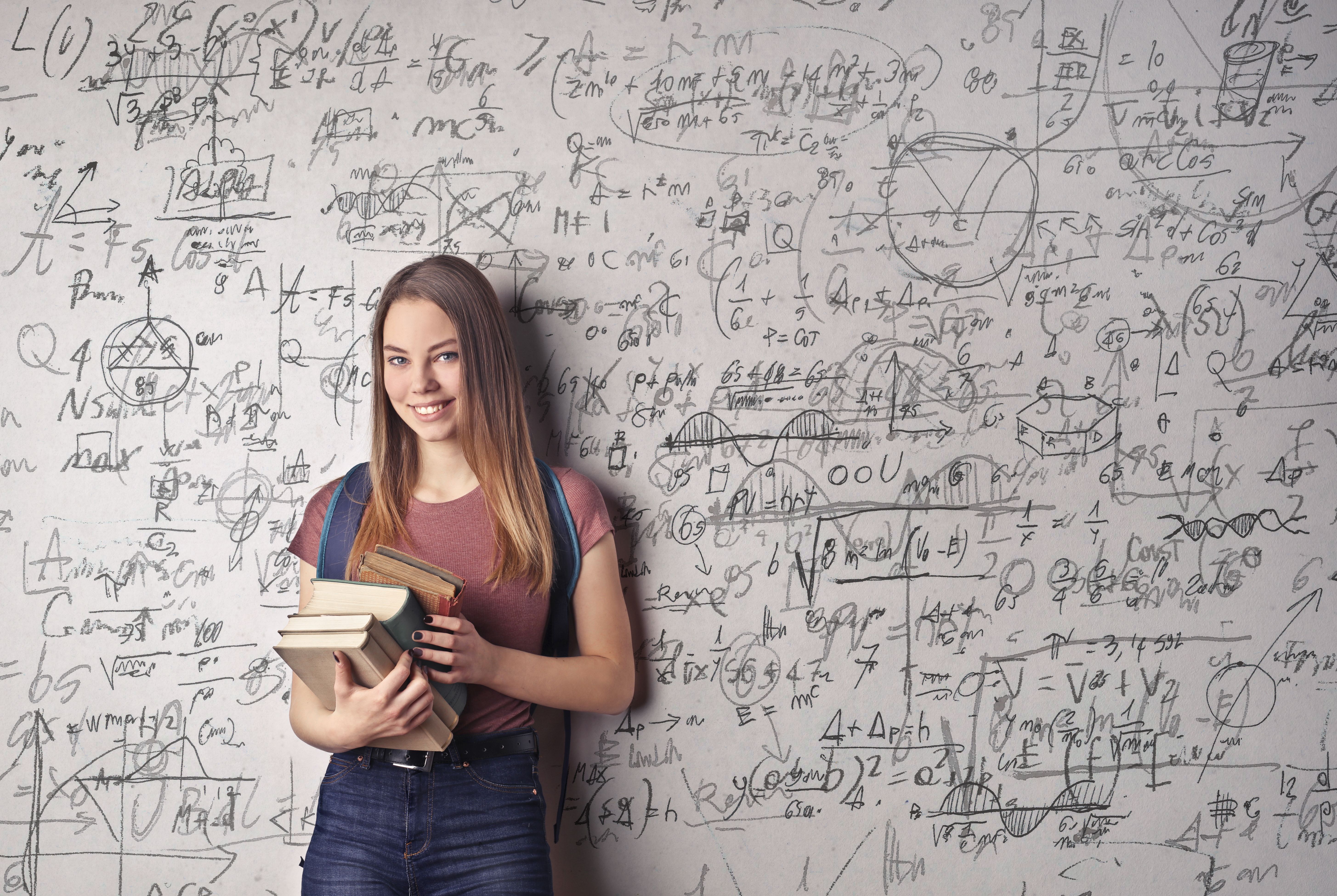 Student calculating study costs using laptop and calculator